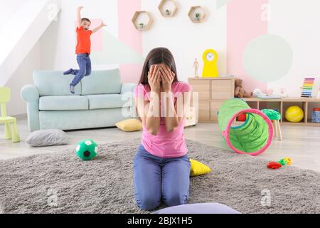 Junge Kindermädchen in Verzweiflung und lästigen Kind zu Hause Stockfoto