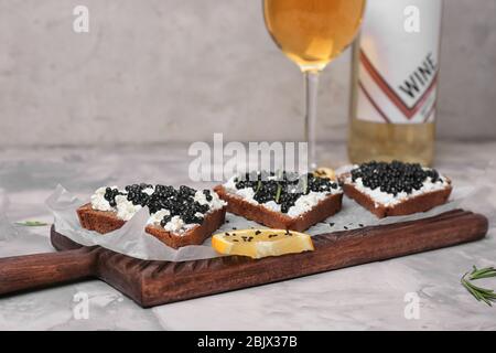 Sandwiches mit köstlichem schwarzen Kaviar und Wein auf dem Tisch Stockfoto