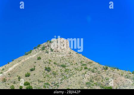 Einweisses Kreuz auf dem felsigen Berg Stockfoto