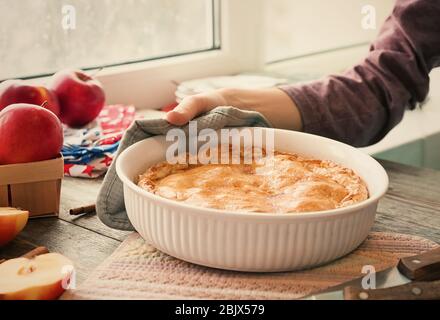 Frau, die American Apple Pie auf den Tisch legt Stockfoto