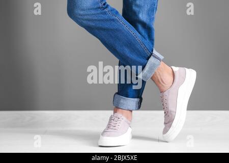 Mann in lässigen Schuhen nahe grauer Wand Stockfoto