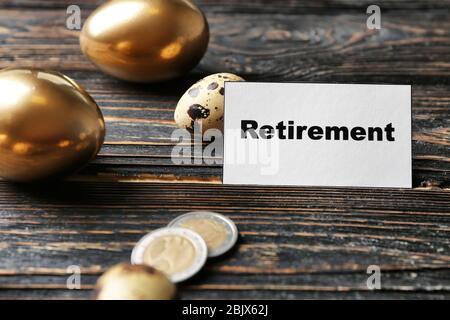 Eier, Münzen und Schilder AUF Holzhintergrund. Pensionsplanung Stockfoto