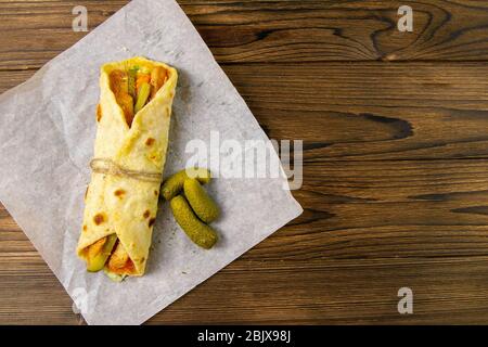 Köstlicher türkischer Döner Kebab auf Pita-Brot mit rasierten gebratenem Fleisch aus einer traditionellen vertikalen Rotisserie, serviert mit frischen Salatzutaten Stockfoto