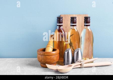 Kochutensilien und Flaschen mit Öl auf dem Tisch Stockfoto
