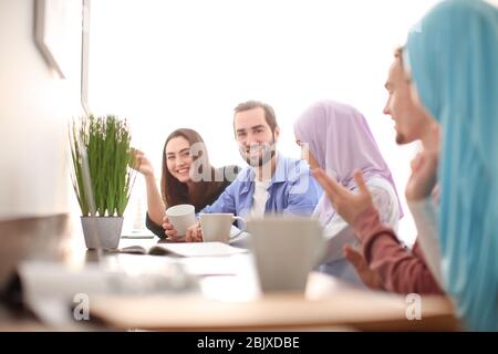 Muslimische Studenten mit ihren Klassenkameraden in der Bibliothek Stockfoto