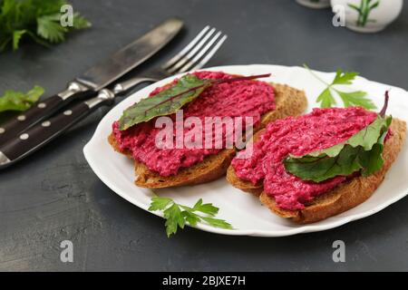 Sandwiches mit Rote Bete und Frischkäse auf weißem Teller auf dunklem Betongrund, Nahaufnahme, Horizontal Format Stockfoto