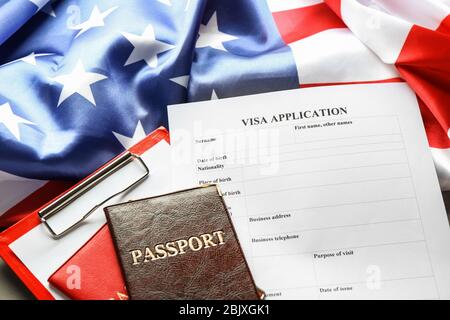 Pässe, amerikanische Flagge und Visa-Antragsformular auf dem Tisch. Einwanderung in die USA Stockfoto