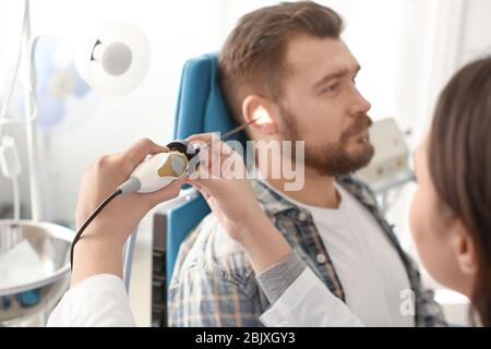 Otharyngologe untersucht das Ohr des Mannes mit HNO-Teleskop im Krankenhaus. Hörproblem Stockfoto