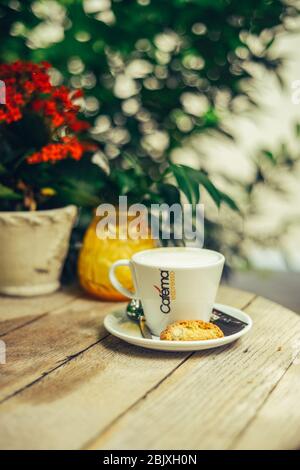 Tasse Milch mit Blumenstrauß über Holztisch. Traditionelle gesunde Bio-Lebensmittel-Konzept. Stockfoto