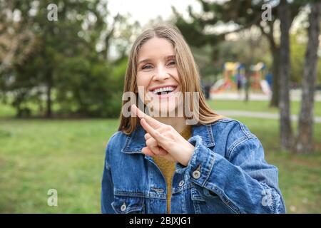 Junge taubstumme Frau, die Gebärdensprache im Freien Stockfoto