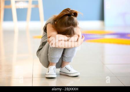Trauriges kleines Mädchen mit autistischen Störung im Spielzimmer Stockfoto