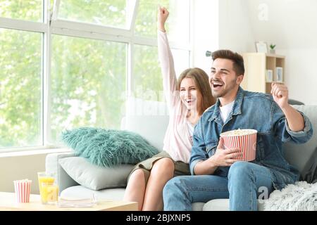 Glückliches Paar Sportveranstaltungen im Fernsehen zu Hause Stockfoto