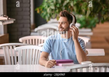 Junger Mann hören in Cafe zu Hörbuch Stockfoto
