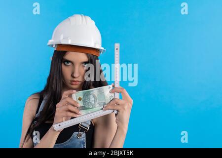 Eine Frau im Hut hält ein Bündel Banknoten in der Hand und fördert die Zusammenarbeit. Stockfoto