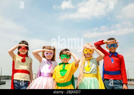 Süße kleine Kinder als Superhelden im Freien gekleidet Stockfoto