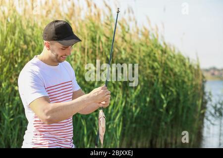 Junger Mann angeln am Fluss Stockfoto