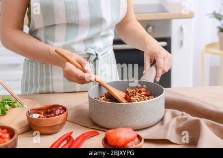 Frau kochen traditionelle Chili con carne in der Küche Stockfoto