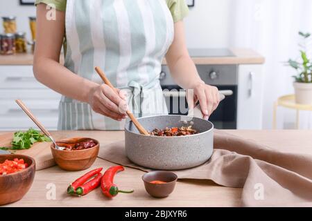 Frau kochen traditionelle Chili con carne in der Küche Stockfoto