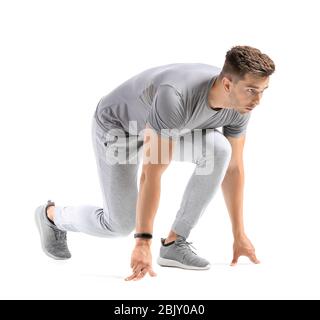 Sportlicher junger Mann in Crouch Startposition auf weißem Hintergrund Stockfoto