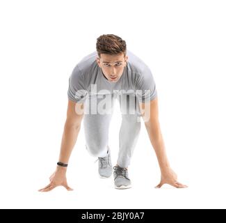 Sportlicher junger Mann in Crouch Startposition auf weißem Hintergrund Stockfoto