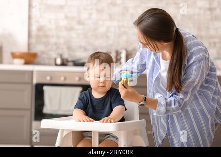 Mutter mit ihrem kleinen Sohn nibbler mit leckerem Essen in der Küche zu Hause. Stockfoto