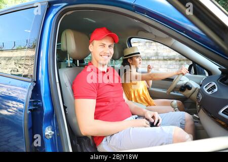 Glückliches junges Paar, die mit dem Auto anreisen Stockfoto
