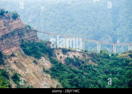 Seitenansicht der Fußgängerbrücke, die nach Cività di Bagnoregio, Civita Bagno, einem alten etruskischen Dorf auf einem Hügel thront auf vulkanischen tu führt Stockfoto