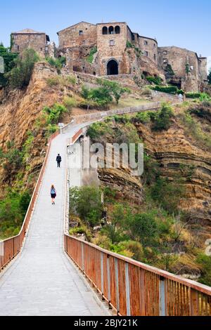 Fußgängerbrücke, die nach Cività di Bagnoregio führt, Civita Bagno, ein altes etruskischen Dorf auf einem Hügel, das auf vulkanischen Tufta-Felsen im Süden thront Stockfoto