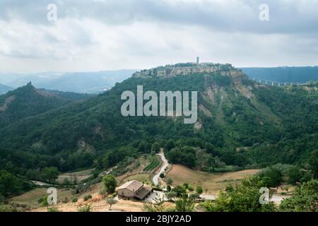 Fernsicht auf Cività di Bagnoregio über die lokalen Bauernhöfe. Civita Bagno, ein altes etruskischen Dorf auf einem Hügel, das auf vulkanischem Tufta-Felsen im Süden thront Stockfoto