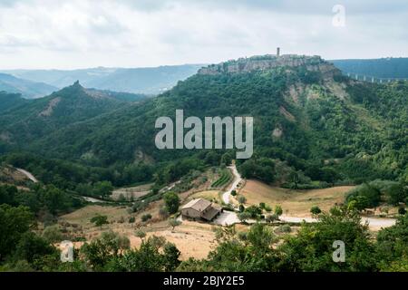 Fernsicht auf Cività di Bagnoregio über die lokalen Bauernhöfe. Civita Bagno, ein altes etruskischen Dorf auf einem Hügel, das auf vulkanischem Tufta-Felsen im Süden thront Stockfoto