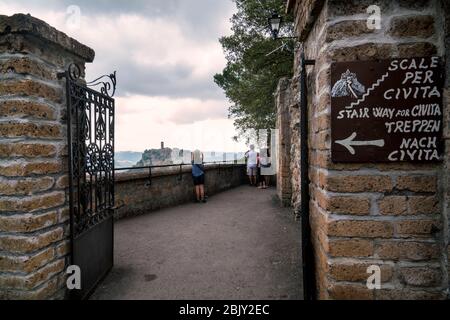 Eingang zur langen Fußgängerbrücke, die nach Cività di Bagnoregio führt, Civita Bagno, einem alten etruskischen Dorf auf einem Hügel, der auf vulkanischem tu thront Stockfoto