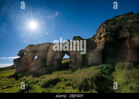 Sunstar über den Caiplie Caves, oder Coves, Felsformation entlang der Nordsee auf dem Fife Coastal Path, Crail, Schottland, Europa Stockfoto