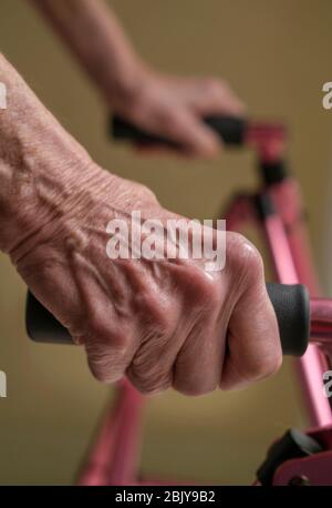 Nahaufnahme der Hände einer älteren Frau auf einem Gehwagen Stockfoto