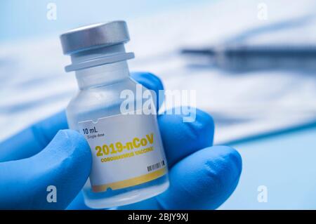 Nahaufnahme eines Handglopped-Fläschchens mit Coronavirus-Impfstoff Stockfoto