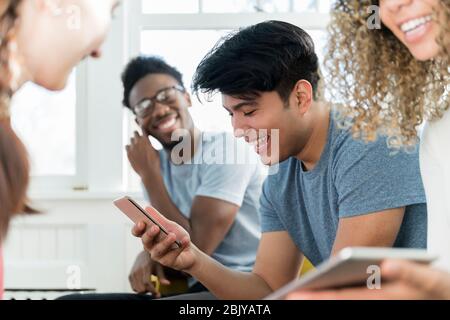 Mann, der mit dem Telefon telefoniert, während er mit friendsÂ rumhängt Stockfoto