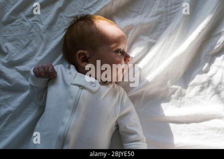 Baby Junge (2-5Â Monate) liegt auf dem Bett Stockfoto