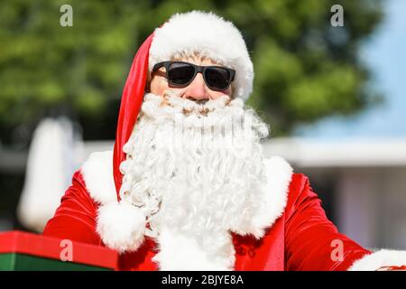 Cool Weihnachtsmann mit Geschenken an Resort Stockfoto