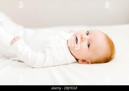 Porträt eines Jungen (2-3 Monate) auf dem Bett liegend Stockfoto