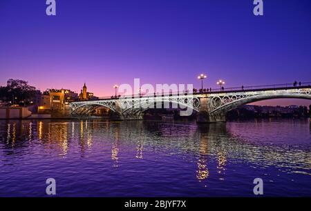 TRIANA BRÜCKE SPIEGELT IN GUADLAQUIVIR FLUSS, SEVILLA, ANDALUSIEN, SPANIEN Stockfoto