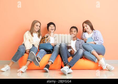 Portrait von jungen Studenten mit dem Laptop in der Nähe der Farbe Wand Stockfoto