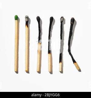 Reihe verbrannter Streichhölzer auf weißem Hintergrund Stockfoto