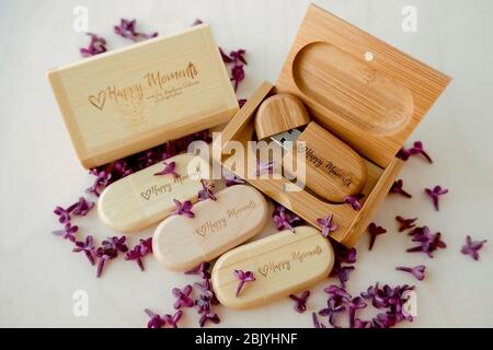 Holz braun usb-Flash-Laufwerke mit Boxen mit dem Text Happy Moments mit lila Blütenblätter auf einem weißen Hintergrund, Datenspeicher, schönes Feedback zu clie Stockfoto