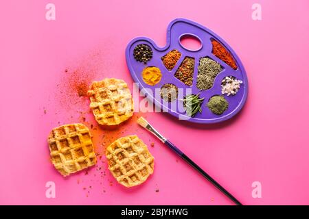 Kreative Komposition mit Waffeln und Gewürzen auf farbigen Hintergrund Stockfoto