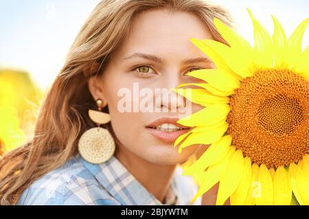 Schöne junge Frau im Sonnenblumenfeld auf Sommer Tag Stockfoto