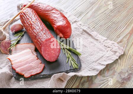 Schiefer Platte mit Auswahl an Würstchen auf hölzernen Tisch Stockfoto