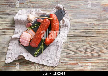 Schiefer Platte mit Auswahl an Würstchen auf hölzernen Tisch Stockfoto