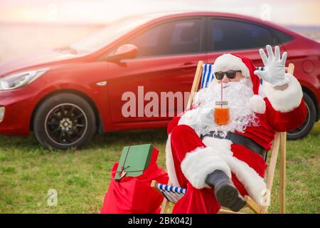 Cool Santa Claus mit Cocktail ruht auf Riverside Stockfoto