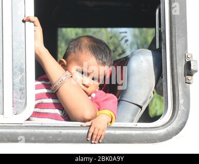 Beawar, Indien. April 2020. Ein Kind schaut durch ein Fenster eines Busses von der Regierung Rajasthan angeordnet, um seine Heimat zu erreichen, während der laufenden landesweiten COVID-19 Sperrung, in Beawar. (Foto von Sumit Saraswat/Pacific Press) Quelle: Pacific Press Agency/Alamy Live News Stockfoto