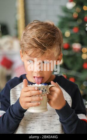 Cute little boy trinken heiße Schokolade mit Marshmallows zu Hause am Heiligabend Stockfoto