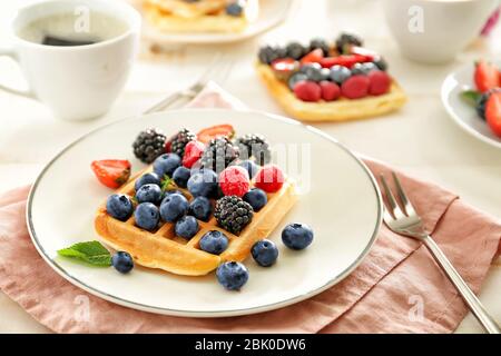Mit leckeren Waffeln und Beeren auf der Tischplatte Stockfoto